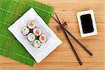 Sushi maki set and soy sauce on bamboo table