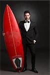 Handsome latino young man holding a surf board