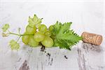 Wine bottle corks and leaves of grape isolated on the white background. Close up. Culinary luxurious wine drinking background, country style.