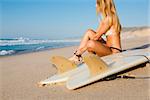 Beautiful woman on the beach getting ready for surf