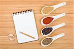 Colorful herbs and spices selection. Aromatic ingredients on cutting board with blank notepad copyspace