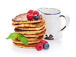 Pancakes with raspberry, blueberry and milk jug. Isolated on white background