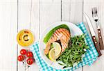 Grilled salmon and whtie wine on wooden table. Top view with copy space