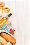 White wine, cheese and bread on white wooden table background. Top view with copy space