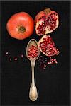 Fresh pomegranate background. Pomegranate core on black background, top view. Healthy fruit eating.