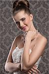 elegant fashion portrait of smiling aristocratic woman with white decorated dress, fine hairdo and precious pearls necklace