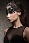Beautiful, gorgeous, stunning brunette woman with transparent mask on the face, make up is dark with pink lips. She is wearing black transparent top.