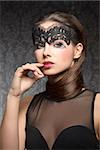 Beautiful, gorgeous, stunning brunette woman with transparent mask on the face and nice hairstyle near the neck, make up is dark with pink lips. She is wearing black transparent top.