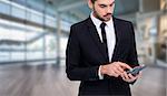 Concentrated businessman in suit using calculator  against fitness studio