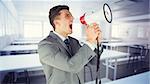 Businessman with megaphone against empty class room