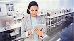 Brunette using tablet pc against empty computer room