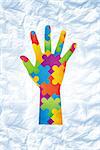 Autism awareness hand against crumpled white page