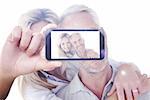 Hand holding smartphone showing against close up portrait of happy mature couple