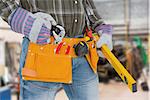 Handyman holding spirit level against workshop