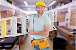 Portrait of smiling repairman carrying ladder against workshop
