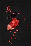 Luxurious pomegranate background. Pomegranate core on black background, top view. Healthy fruit eating.