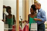 Portrait of black tourist heterosexual couple in Panama City with shopping bags. The man and his girlfriend look at shop window