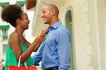 Black tourist heterosexual couple in Casco Antiguo - Panama City with shopping bags. The girl hold a credit card and looks at her boyfriend