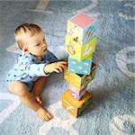 A 15 months baby boy playing with cubes