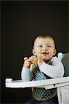 A 15 months baby boy eating on his high chair