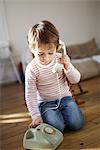 Little boy making a phone call with an old phone