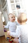 A 10 months baby girl in front of a mirror