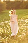 Young woman running in a withered dandelion meadow in spring, Germany