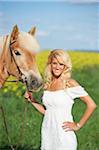 Young woman standing beside a haflinger horse in spring, Bavaria, Germany