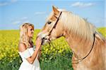 Young woman standing beside a haflinger horse in spring, Bavaria, Germany