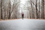 Young female photographer standing on rural forest road