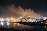 Oil storage tanks and smoke stacks on Puget Sound waterfront at night, Tacoma, Washington State, USA