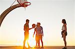 Group of friends playing basketball, outdoors