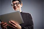 Studio portrait of mature businesswoman reading digital tablet