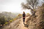 Young woman hiking along dirt track