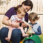 A woman and two children, with a young duckling.