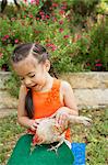 A child with a hen on her lap.