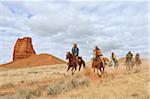 Cowboys and Cowgirls Riding Horses with Castel Rock in the background, Shell, Wyoming, USA