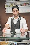 Barista serving coffee over the counter