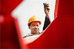 Worker using equipment in crane manufacturing facility, China