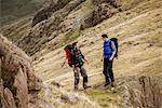 Two young male hiking friends laughing and chatting, The Lake District, Cumbria, UK