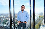 Portrait of  businessman in front of office window with Brussels cityscape, Belgium