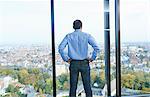 Rear view of businessman looking from office window at Brussels cityscape, Belgium