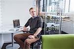 Young man gazing from office desk