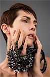 Studio portrait of woman with black beads between her fingers