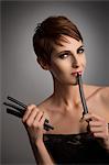 Studio portrait of woman holding up licorice stick to her lips