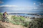 Male mountain biker speeding downhill on coastal path, Cagliari, Sardinia, Italy