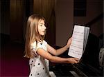 Girl choosing sheet music for piano