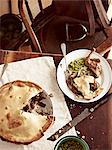 Rustic table with meal of raised pigeon pie