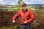 Male teenage hiker checking walking pole on heather moors, Pateley Bridge, Nidderdale, Yorkshire Dales