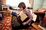 Mother and son playing with cardboard boxes in living room